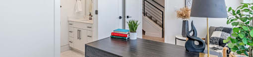 a home office with a desk and a door leading to a staircase