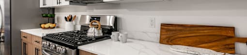 a kitchen with white cabinets and a stove and a microwave
