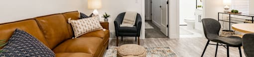 a living room with a brown couch and a dining room table