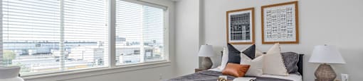 a bedroom with a bed and two windows