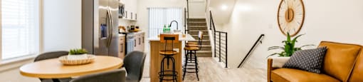 a living room with a table and chairs and a kitchen