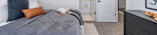 bedroom with a bed and dresser and a door leading to a bathroom