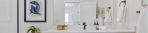 bathroom with a toilet, sink, and mirror