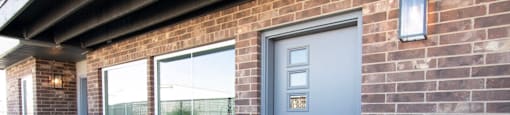 front door of unit with windows and brick front