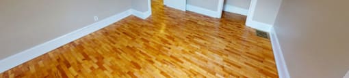 A room with wooden flooring and two doors.