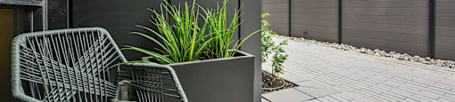 A patio with a chair and a planter.