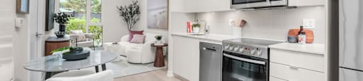 A modern kitchen with white cabinets and a glass table.