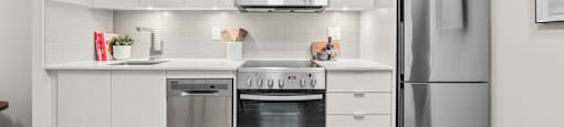 A modern kitchen with a stainless steel refrigerator, oven, and microwave.