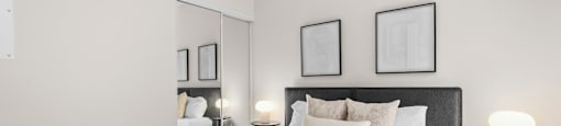 A bedroom with a large bed and two nightstands with lamps.