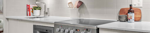 A modern kitchen with a stainless steel oven and microwave above it.