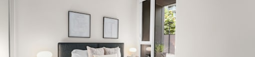 A bedroom with a large bed and two nightstands with lamps.