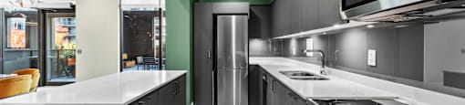 A modern kitchen with a stainless steel refrigerator and microwave.