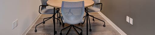 A conference room with a round table and four chairs.