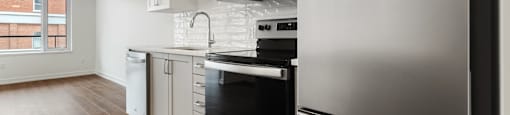 A modern kitchen with stainless steel appliances and white cabinets.
