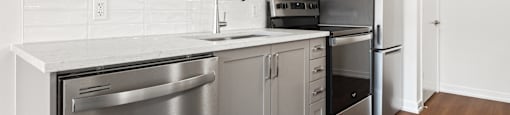 A kitchen with white cabinets and stainless steel appliances.