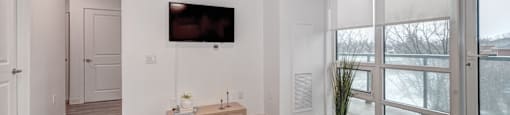 A living room with a flat screen TV mounted on the wall.