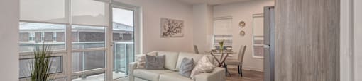 A living room with a white couch and a rug.