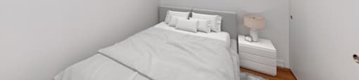 A bedroom with a bed, nightstand, and two pictures on the wall.