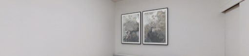 A bedroom with a bed, nightstand, and two pictures on the wall.