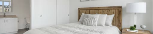 A bedroom with a large bed and a wooden headboard.