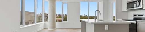 A kitchen with a large island and a view of the city.