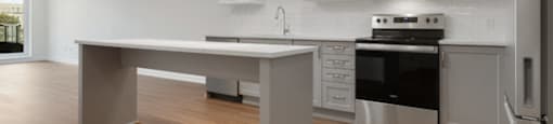 A modern kitchen with a large island and stainless steel appliances.