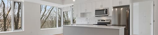 A modern kitchen with a large island and stainless steel appliances.
