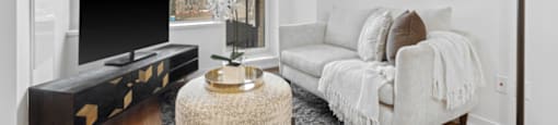 A living room with a white couch and a television.