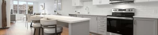 A modern kitchen with a white color scheme and stainless steel appliances.