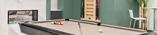 A pool table with a white ball and a cue stick on it.