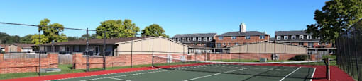 Tennis court with buildings in the background.