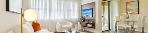 A modern living room with a white sofa and a glass coffee table.