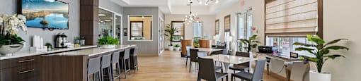 A modern kitchen with a bar area and a dining table.