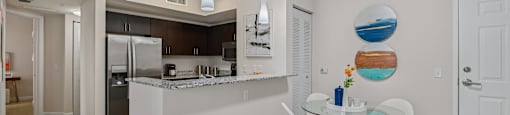 A kitchen with a table and chairs in the middle of the room.