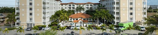 A large apartment complex with a parking lot in front.