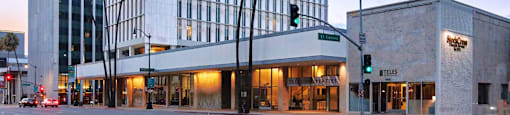 A modern building with palm trees in front of it.
