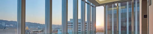 A room with a view of the cityscape at sunset.