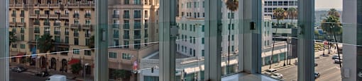 A view from a window looking out at a street with cars and buildings.