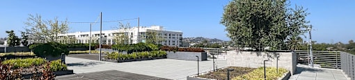 A large open area with a wooden deck and a concrete walkway.