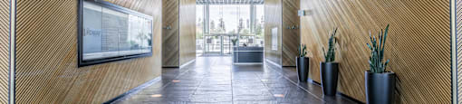 A hallway with a wooden wall and black flooring.