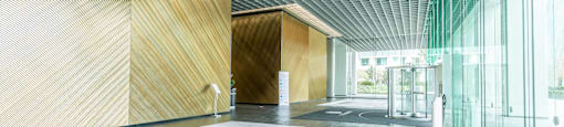 A long hallway with a glass wall on one side and wooden walls on the other.