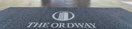 A hallway with a carpet that says "The Ordway" on it.