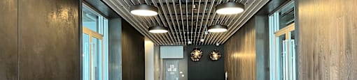 A long hallway with wood floors and ceiling lights.