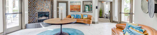 A living room with a blue rug and a brown couch.