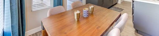 A dining room with a wooden table and chairs.