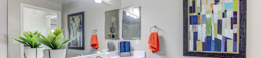 A bathroom with a white counter top and a large mirror.