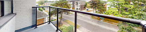 A balcony with a view of a road and buildings.