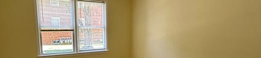 A room with wooden flooring and a window.