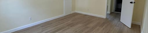 A room with wood flooring and two doors.