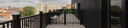 A balcony with a black railing and a black door.